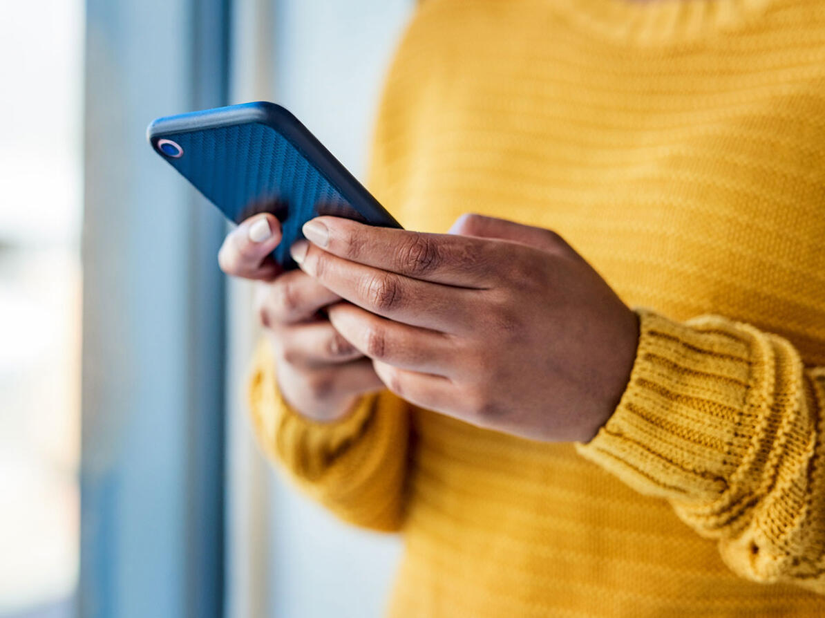 Hænder holder mobiltelefon