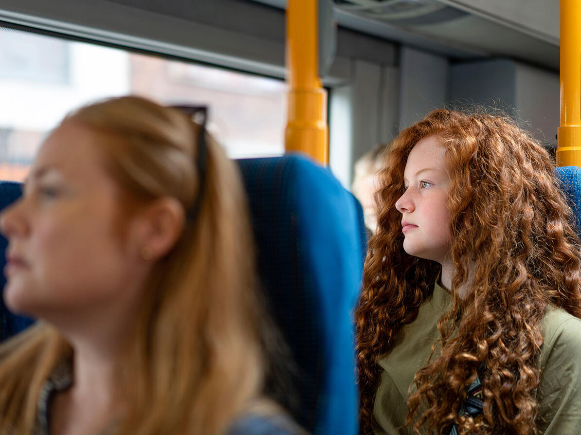 To passagerer sidder i bus og kigger ud ad vinduet