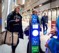 Rejsekortstander på metrostation med passagerer i baggrunden