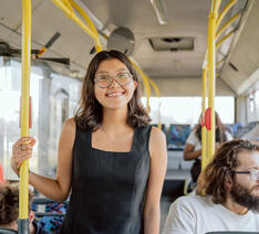 Passager står i bus og smiler 