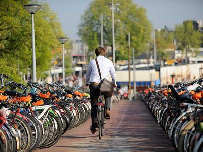 Mand kører på cykel ved cykelparkering 